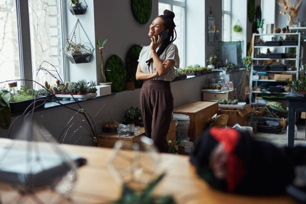 istock Attractive merry dark-haired florist talking on the cellphone 1319577368