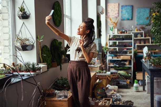 istock Cute dark-haired joyful florist taking a selfie with a smartphone 1319577374