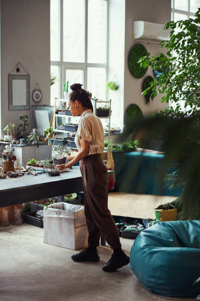 istock Concentrated florist adding a layer of soil to a polyhedron florarium 1319577432