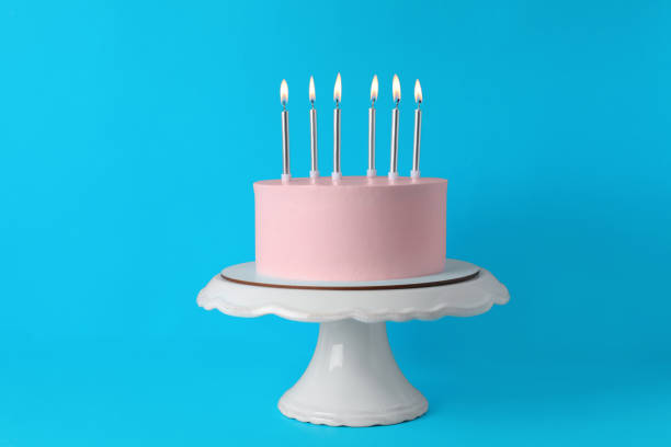 istock Birthday cake with burning candles on light blue background 1319578253