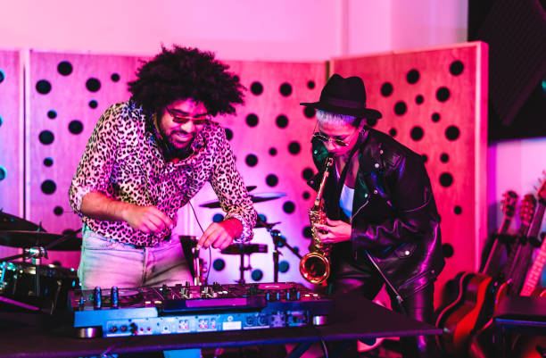 jóvenes felices tocando música con mezclador de dj y saxofón en el estudio de la casa - concepto de entrada del músico juvenil - musica popular fotografías e imágenes de stock