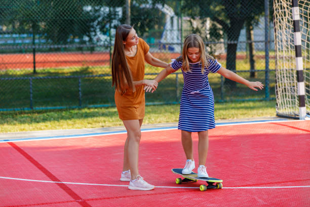 istock Young Mother is Having Fun With her Daughter While They Riding a Skateboard Together. 1319581585