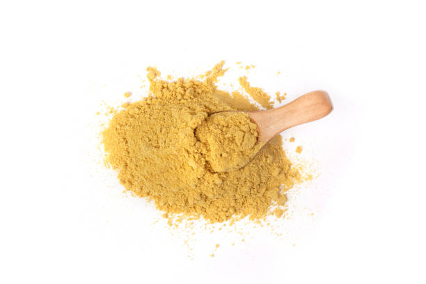 istock Powder mustard with wooden spoon isolated on a white background. 1319581751