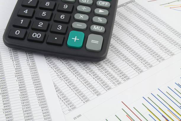 istock Calculator on financial reports with graphs close up. 1319584050