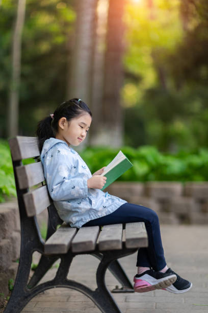 istock Little Girl Reading Book 1319584098