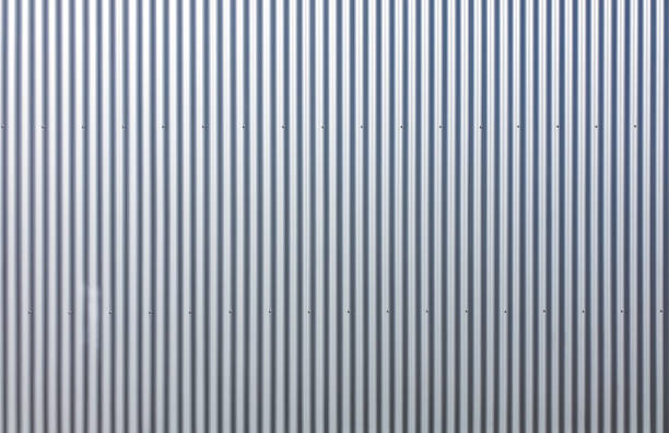 Texture of a wall made of silver corrugated sheet. Exterior wall of a warehouse made of aluminum sheet. corrugated iron stock pictures, royalty-free photos & images