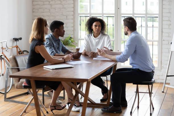 istock Motivated young mixed race business people discussing project. 1319587090