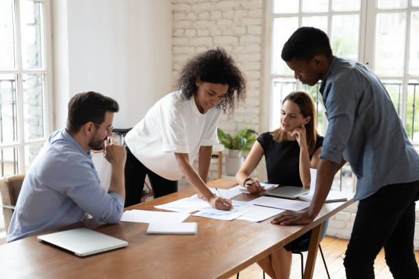 istock Motivated diverse colleagues analyzing paper report in office. 1319587095