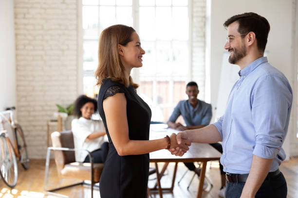 istock Smiling male team leader shaking hands with employee. 1319587105