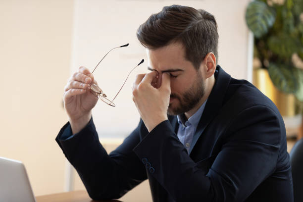 istock Overwhelmed young male manager taking off eyeglasses. 1319587128