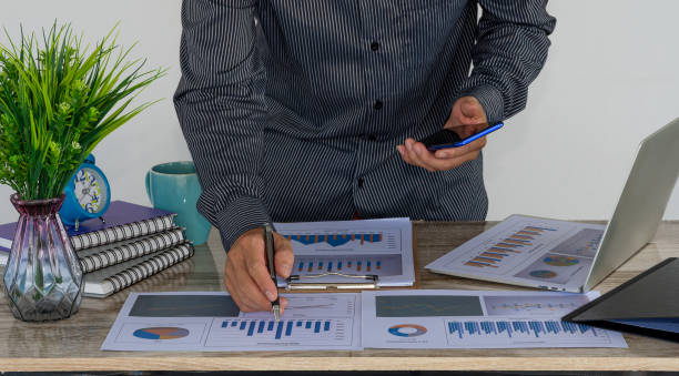 istock Business people doing business in finance and calculating, analyzing, graphing the cost of investments, real estate and more. Tax system on the desk with laptop on the table in the home office. 1319587607