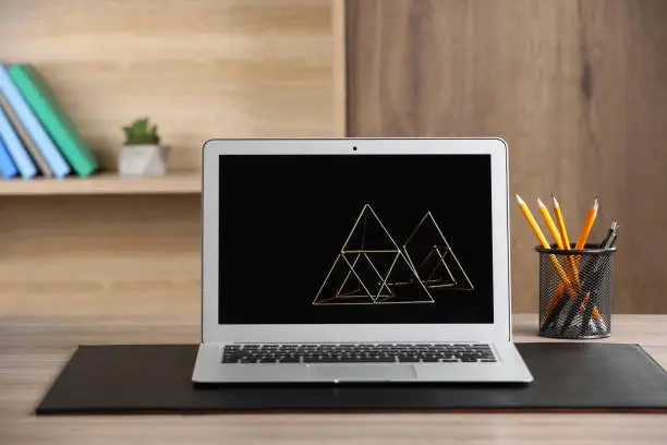 Modern laptop and office supplies on wooden table indoors