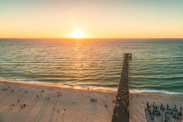 Glenelg beach jetty  with people at sunset viewed from above