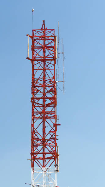 istock Telecom tower closeup with white and red color and blue sky. 1319592586