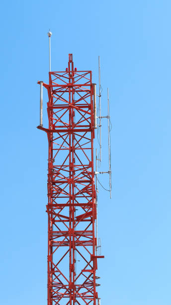 istock Telecom tower closeup with white and red color and blue sky. 1319592591