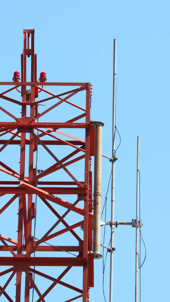 istock Telecom tower closeup with white and red color and blue sky. 1319592605
