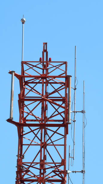 istock Telecom tower closeup with white and red color and blue sky. 1319592609