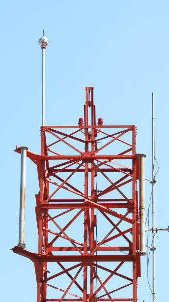 istock Telecom tower closeup with white and red color and blue sky. 1319592615