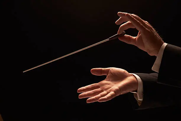 Photo of Concert conductor hands with baton