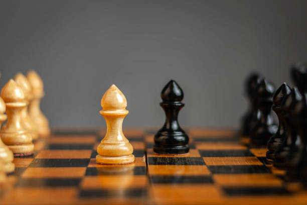 istock White pawn, in front of black, on a chessboard. Selective focus. Correct move. Strategy. Sport. Business. 1319593388
