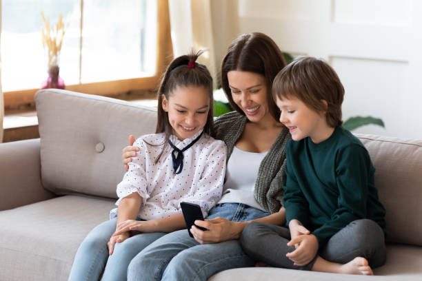 istock Happy mom use cellphone with two kids 1319593763