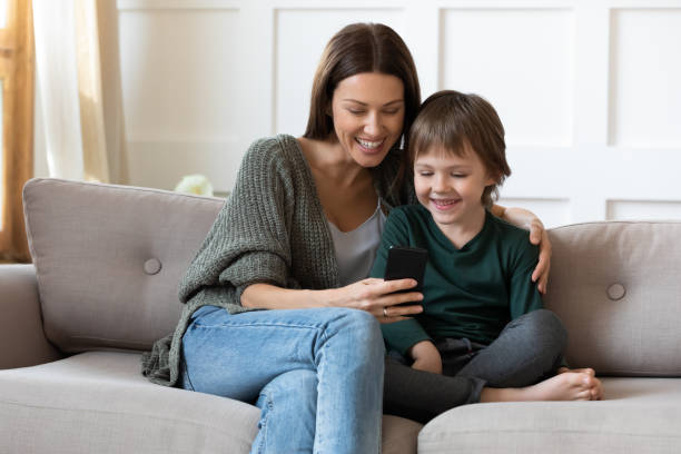 istock Smiling mother and small son play online on smartphone 1319593768