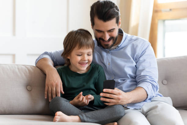 istock Happy father and little son use smartphone playing 1319593770