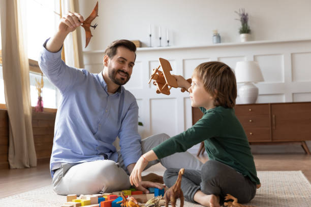 istock Happy dad play toys with small son 1319593775