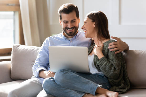istock Smiling Caucasian couple have fun using laptop 1319593803