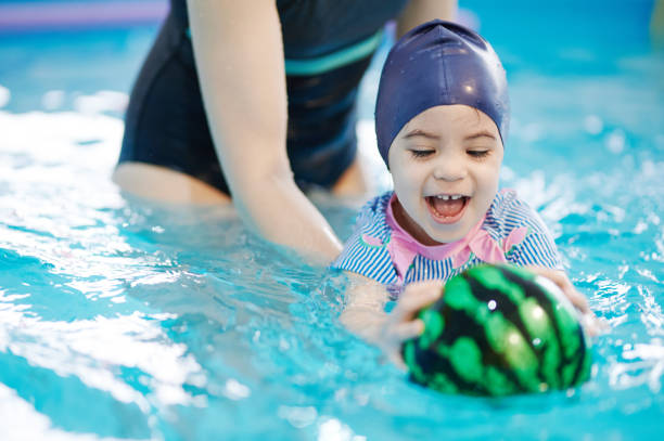 istock Kid catch ball on swim lesson 1319596881