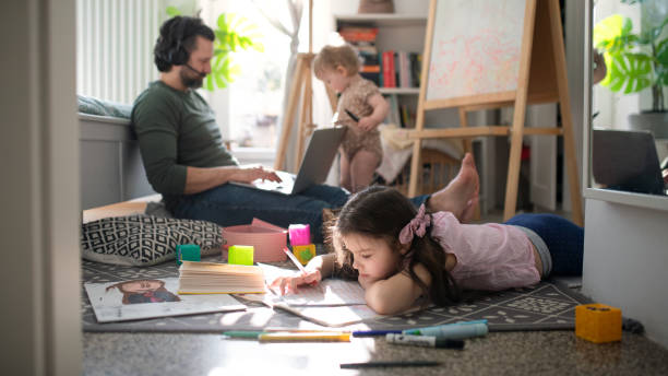 istock Father working with small daughters in bedroom, home office concept. 1319596896