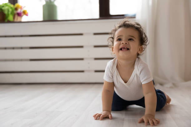 istock Smiling African American baby child crawling on floor 1319599229