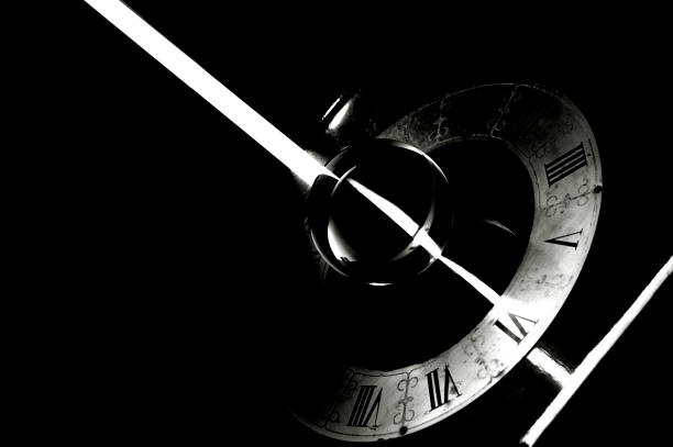 A vintage clock with a bright ray of light in black and white