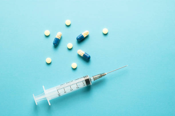 istock A syringe and drugs on blue background 1319599629