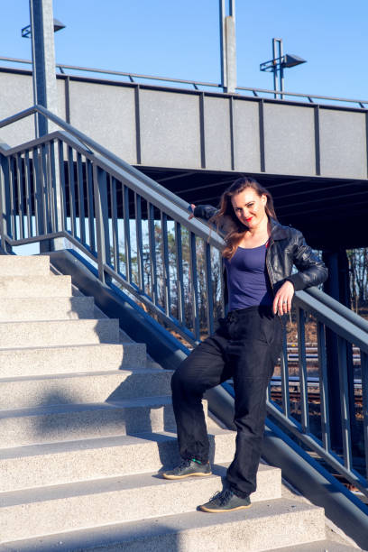 istock young woman in leather jacket standing outdoors on a stair step 1319600641