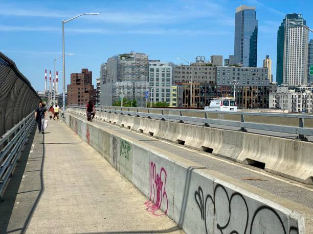 Modes of travel on a city bridge Brooklyn, NY, USA - May 23, 2021: Concrete barriers separating pedestrians, bicyclists and vehicular traffic on Pulaski Bridge warren street brooklyn stock pictures, royalty-free photos & images