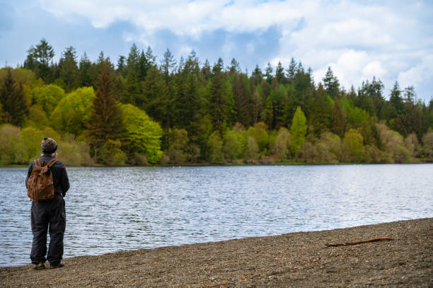 istock Senior man standing beside a lake 1319603017