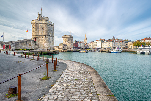 Cobbled pathway leading to fortified medieval towers at the Vieux Port (Old Port) at La Rochelle, Charente Maritime, Poitou Charentes, on the Atlantic coast of France