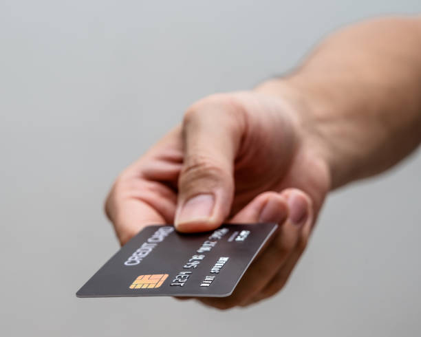 istock Hand hold black card isolated on grey background. 1319609927