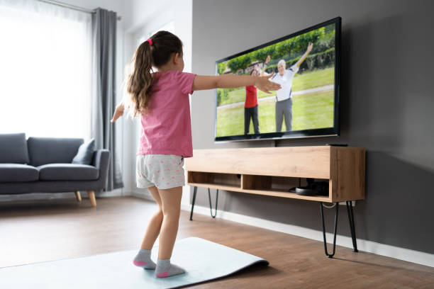 istock Kid Doing Online TV Fitness Exercise 1319611065