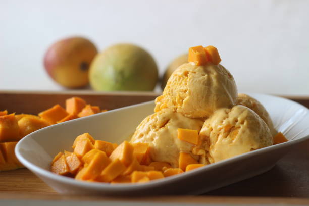 scoops домашнего мороженого манго подается со свежим вырезать lalbagh манго. - lalbagh стоковые фото и изображения