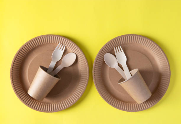 istock Two sets disposable biodegradable tableware of craft paper and wood - plates, forks, spoons, glasses. Zero Waste. View from the top. Flat lay 1319612288