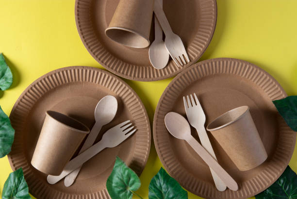 Wooden forks and spoons, eco friendly disposable kitchenware utensils on yellow background. Zero waste concept. Top view.