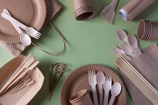 Frame made of disposable biodegradable tableware - craft paper plates, glasses, bags, wooden forks, spoons and bamboo skewers, sushi sticks, parchment. Zero Waste. Top view stock photo