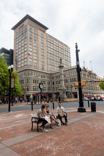 Lancaster, USA - May 15, 2021. Three people sitting on chair chatting in downtown Lancaster city, Pennsylvania, USA