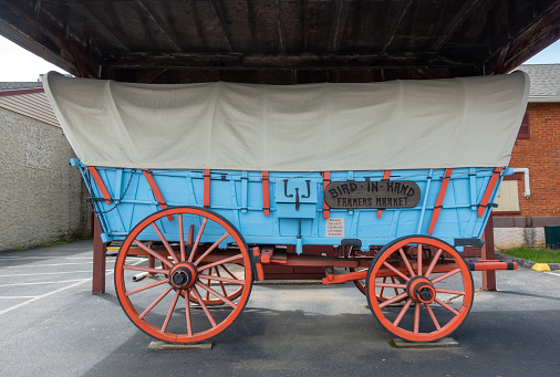 Bird-In-Hand, USA - May 2, 2021. A historic horse drawn carriage car outside an Amish Farmers Market at Bird-In-Hand in Lancaster County, Pennsylvania, USA