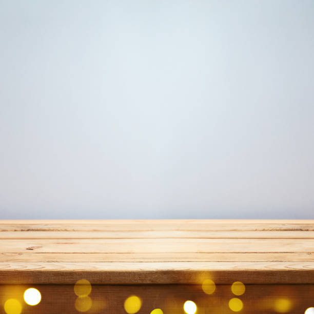 istock Empty wooden table over gray wall background with festive bokeh lights.  Interior mock up for design and product display. 1319618656