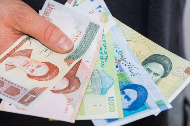istock Iranian bills, Riyal, Assorted values, Money spread out and held in the hand 1319621136