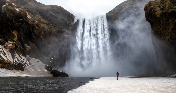 skogafoss waterfall with solitary person - cachoeira imagens e fotografias de stock