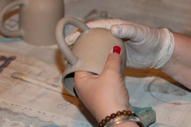 istock ceramic artist woman checking the ceramic cup she shaped 1319621700